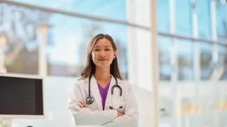 Healthcare professional stands in front of a large window